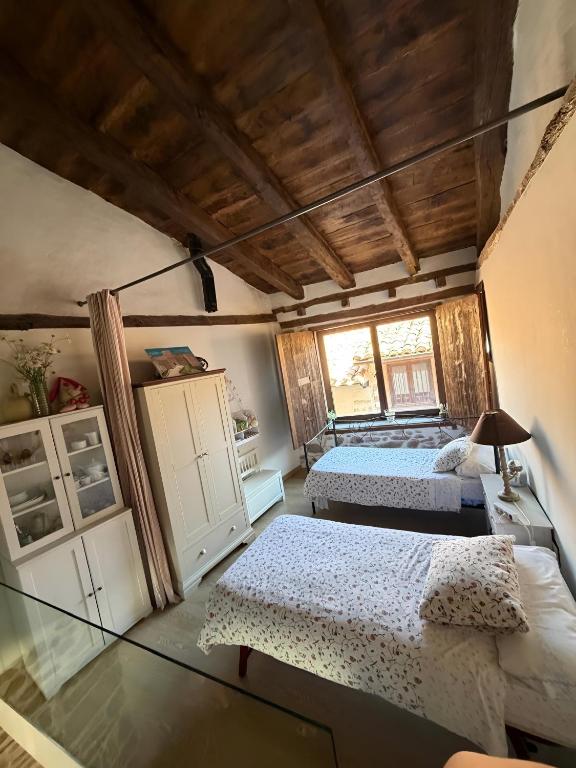 a bedroom with two beds and a window at Casita del Castillo Mora de Rubielos in Mora de Rubielos