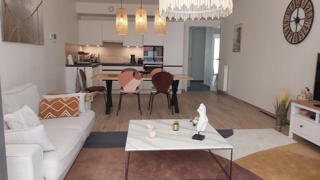 a living room with a white couch and a table at Courbevoie lodge Louvain-la-Neuve in Louvain-la-Neuve