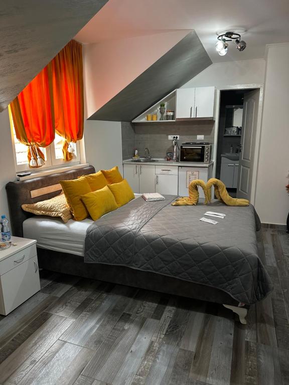 a bedroom with a large bed with yellow pillows at Apartmani Romansa in Irig