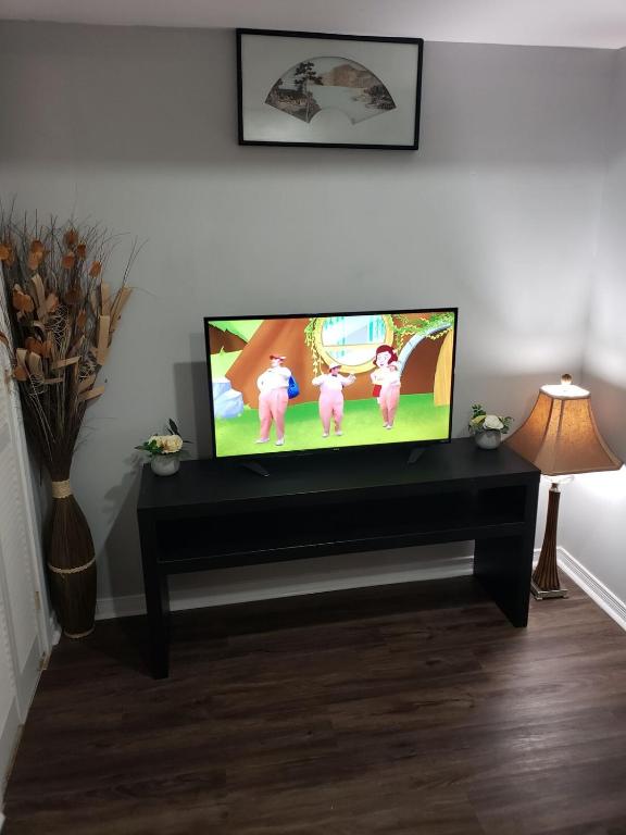 a flat screen tv sitting on a stand in a living room at Beautiful home in Brampton