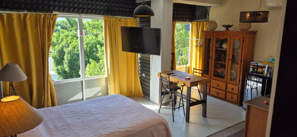 a bedroom with a bed and a desk and a television at Edificio Bermejo Suites in La Paz