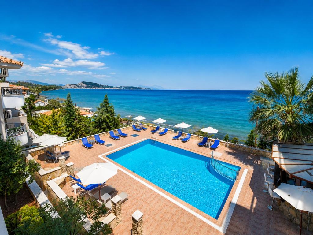 a view of a swimming pool and the ocean at Nefeli Beach - living by the sea in Argassi