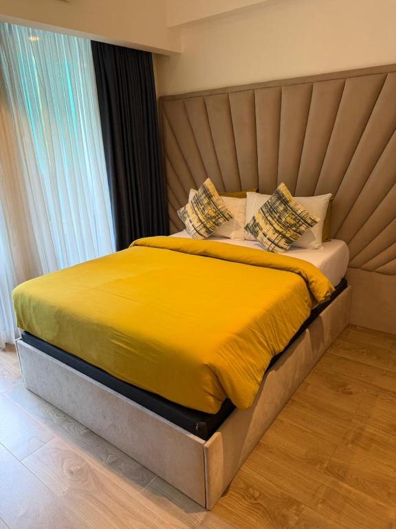 a bedroom with a bed with yellow sheets and pillows at 1bedroom at Solaris in Accra