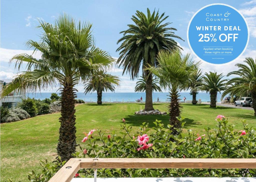 a sign for winter deal off at a park with palm trees at The Hibiscus - Coast & Country in Onetangi