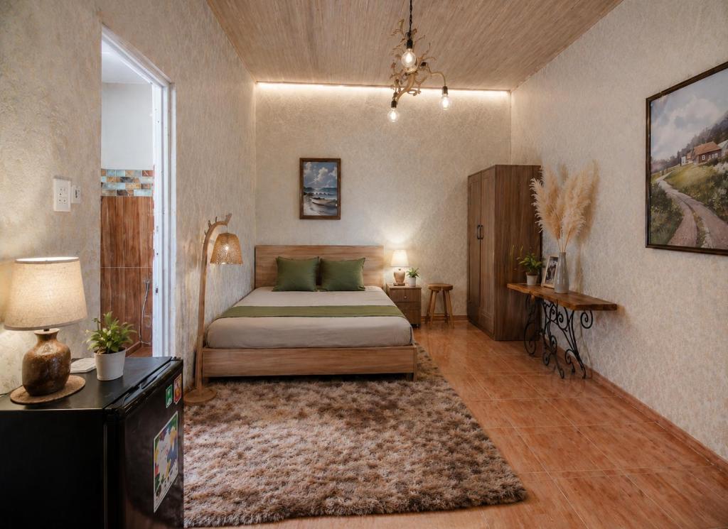 a bedroom with a bed and a table and a rug at PINE-APPALE Riverside Resort in Ấp Kế Mỹ