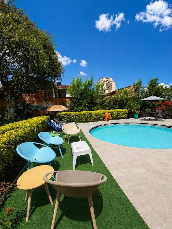 a group of tables and chairs next to a swimming pool at Green Door San Gil in San Gil