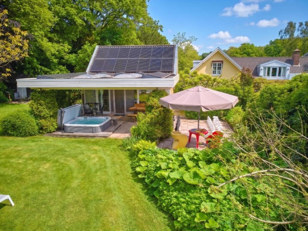 a house with a solar array on the roof at Wellnesshuisje Engelse Tuin in Oldenzaal