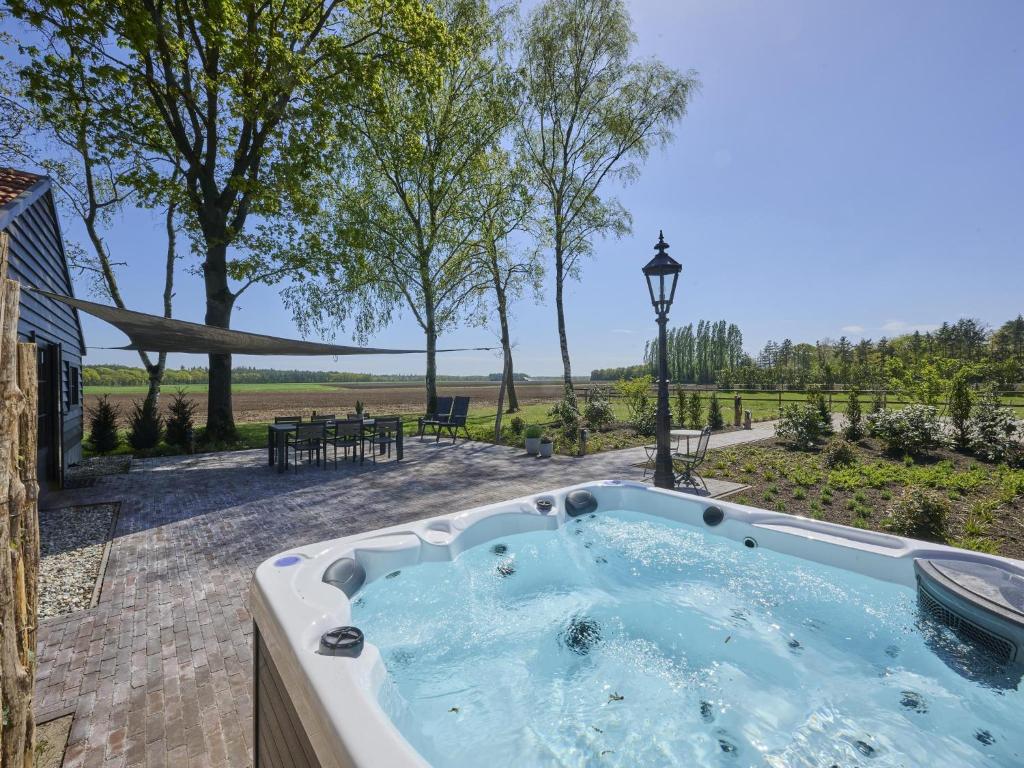 a jacuzzi tub in the backyard of a house at Guesthouse het Koetshuis in Bladel
