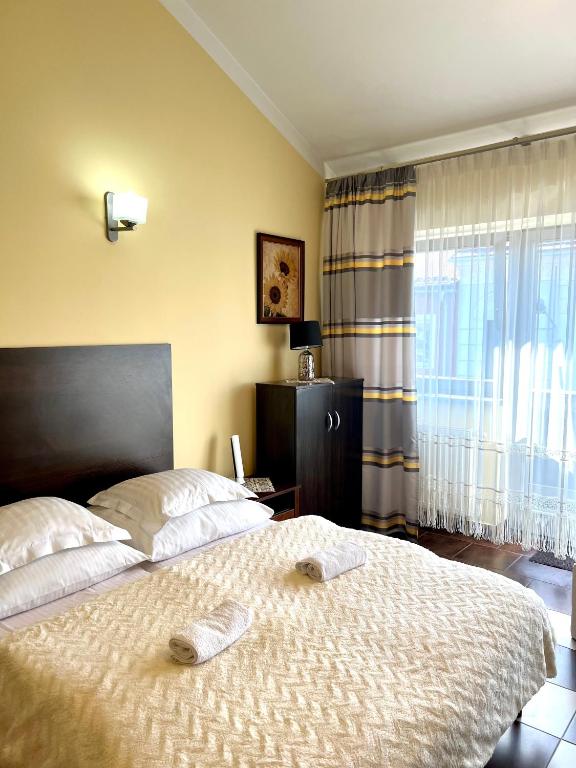 a bedroom with a large bed and a window at Żywiec CENTRUM Apartamenty z aneksem kuchennym & łazienką in Żywiec