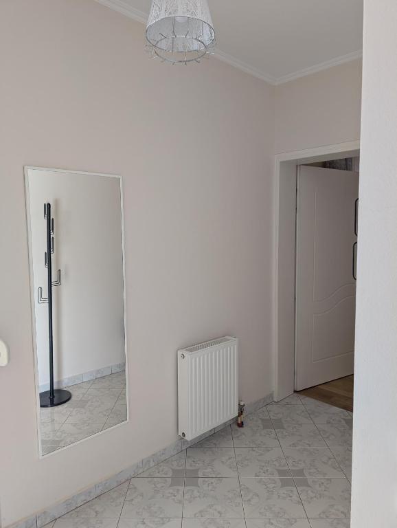 a white room with a mirror and a radiator at Vila Albert in Gjirokastër