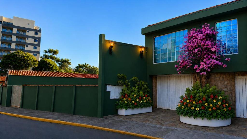 a green house with flowers in front of it at Apartamento São Pedro SP in São Pedro