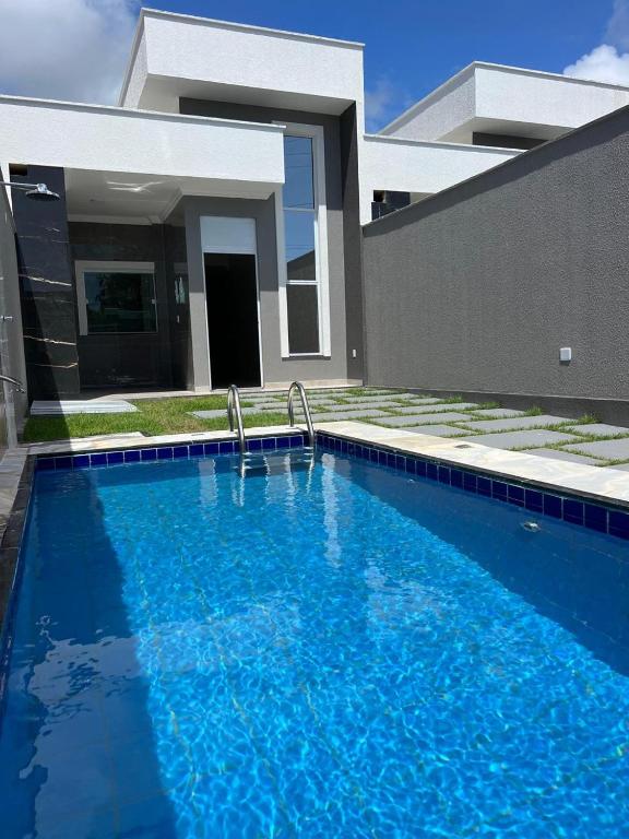 a large blue swimming pool in front of a house at Xodó de Casa, Paracuru in Paracuru
