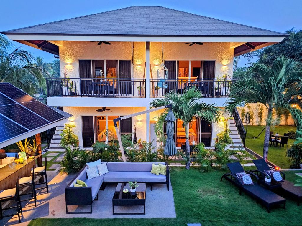 a house with a patio with a blue couch at Hazel's Suites in Dauin
