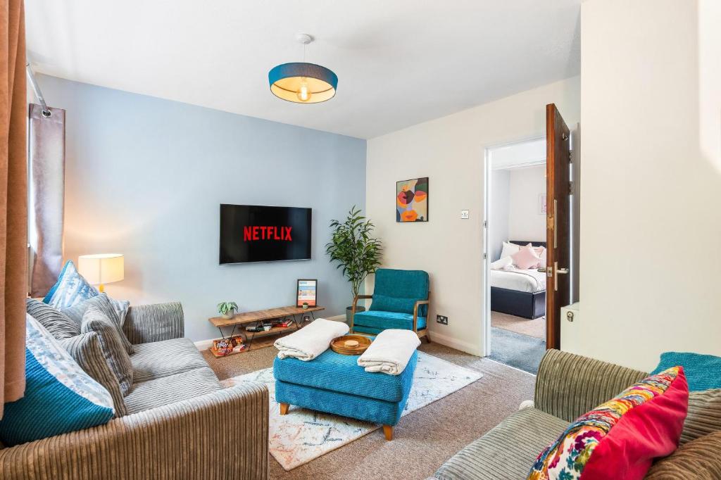 a living room with a couch and chairs and a tv at Downs Escape By My Getaways in Lancing
