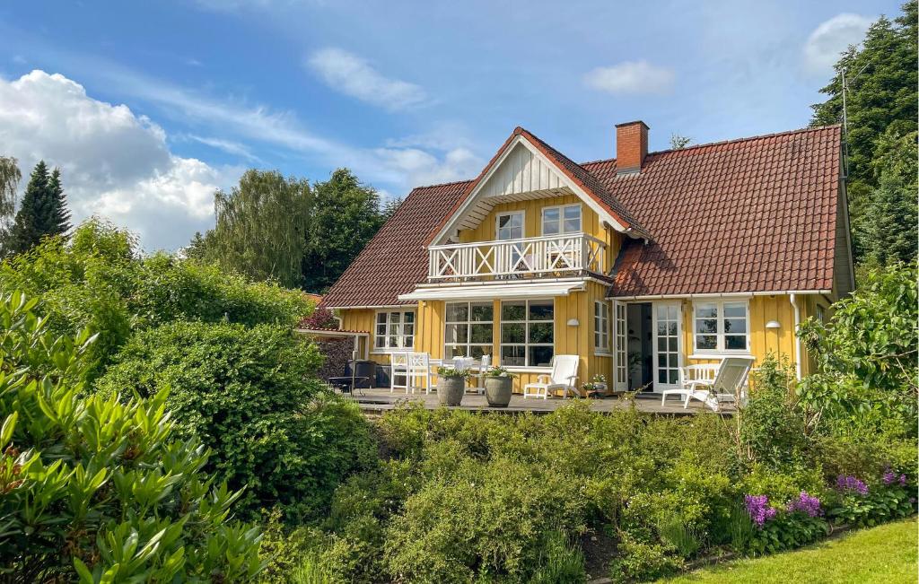 a yellow house with a porch and a deck at 3 Bedroom Beautiful Home In Bryrup in Bryrup