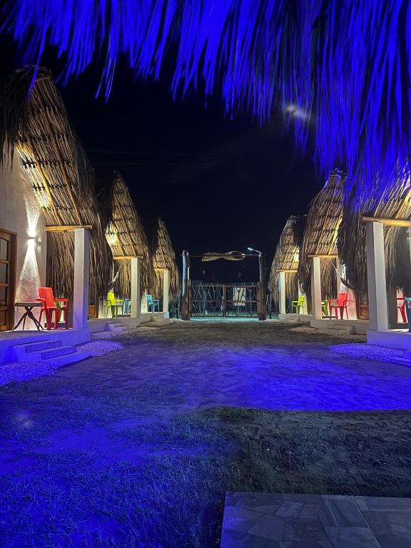 a night view of a resort with blue lights at Karpatty Mar Cabañas in San Bernardo del Viento