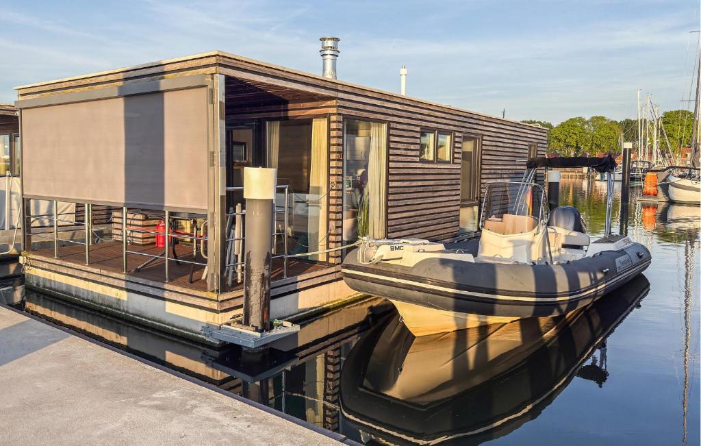 ein kleines Haus am Wasser mit einem Boot in der Unterkunft Mermaid-Hausboote 2 in Lelystad