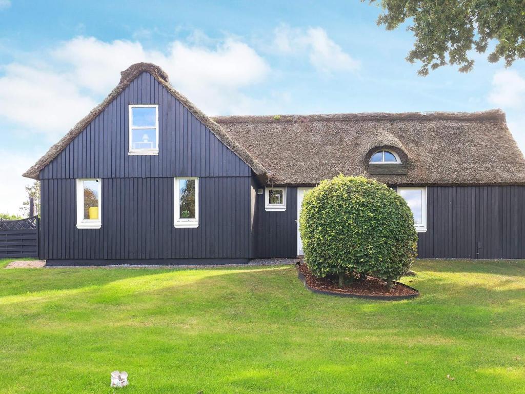 a black house with a thatched roof at Charming cottage near forest in Farsø in Farsø