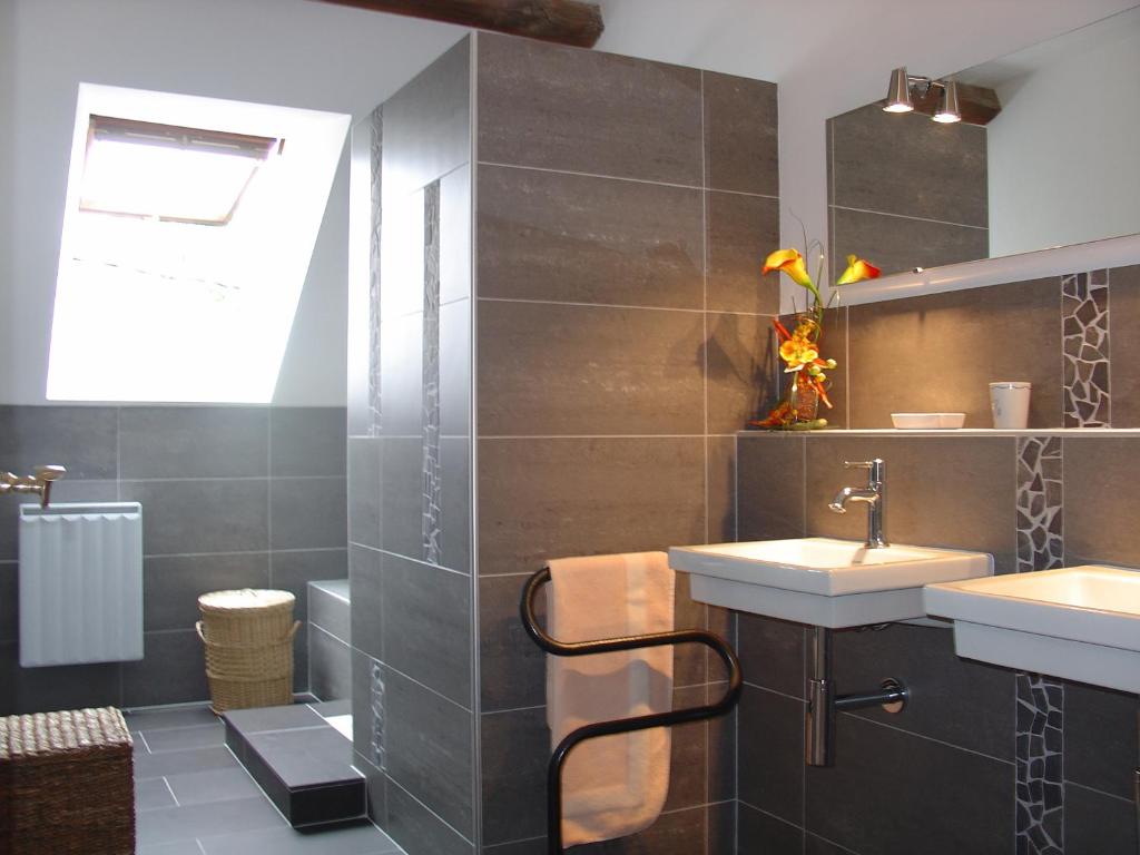 a bathroom with two sinks and a mirror at La Sabotiere in Plumeliau Bieuzy