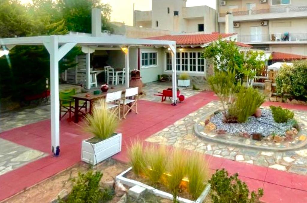 a patio with a table and a pavilion in front of a building at Aggelou Apartments-10 mins from Athens airport in Spata