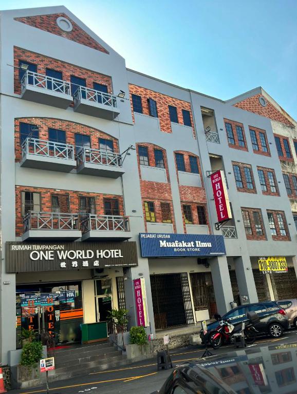 a building on a street with cars parked in front at One World Hotel in Kulai
