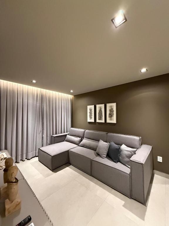 a living room with a gray couch in a room at Apartamento 204 Cheia de Graca in Divinópolis