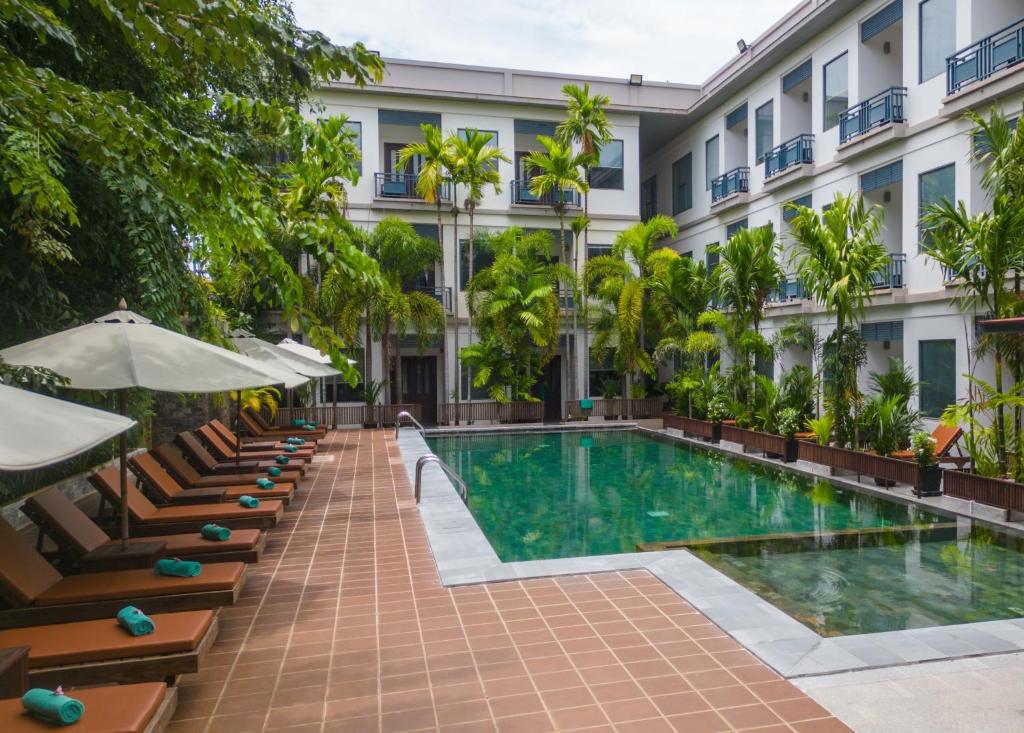a hotel with a swimming pool in front of a building at Green Amazon Residence in Siem Reap