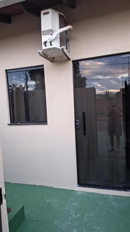 a front door of a building with a view of a person at Suíte privativa com acesso à rua in Dourados