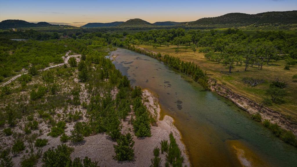 an aerial view of a river with trees and bushes at Nueces River Escape in Uvalde