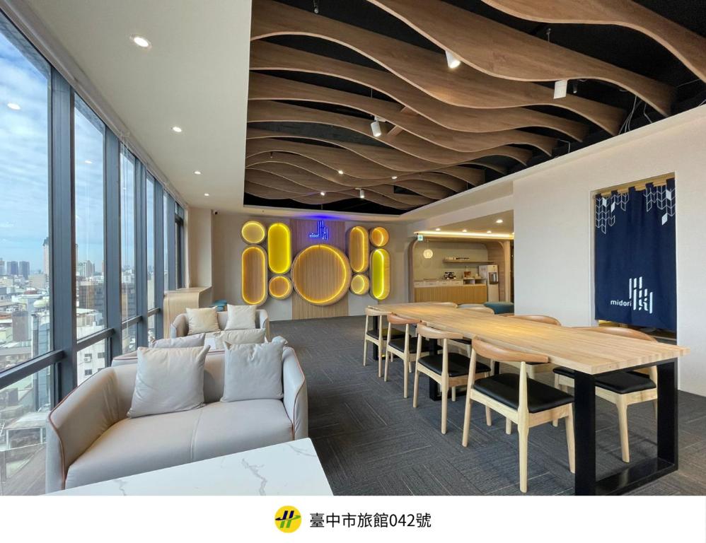 a dining room with a table and a couch at Green Hotel - Midori in Taichung