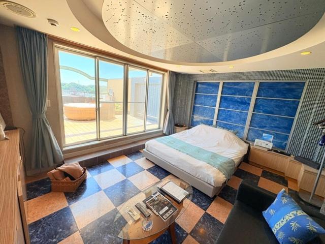 a bedroom with a bed and a large window at avilla RESORT in Iwaki