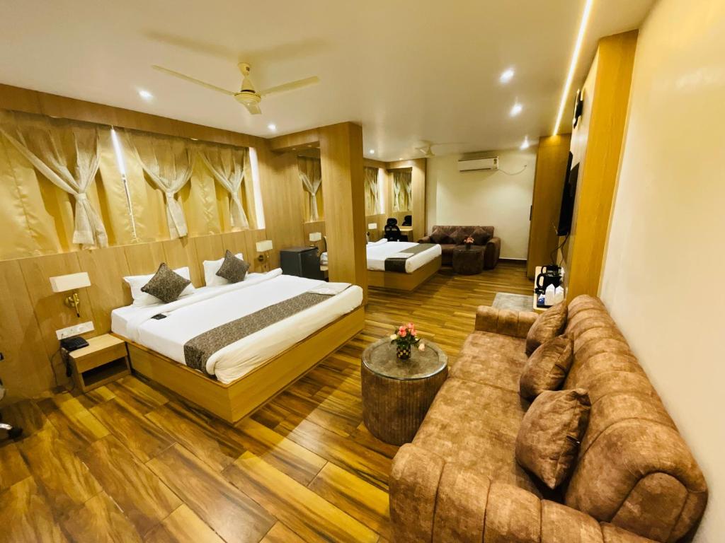 a hotel room with a bed and a couch at Hotel JK palace in Allahābād