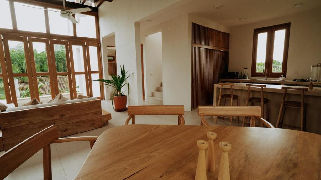 a living room with a wooden table and a kitchen at Aguamiel Agua Blanca in Playa Agua Blanca