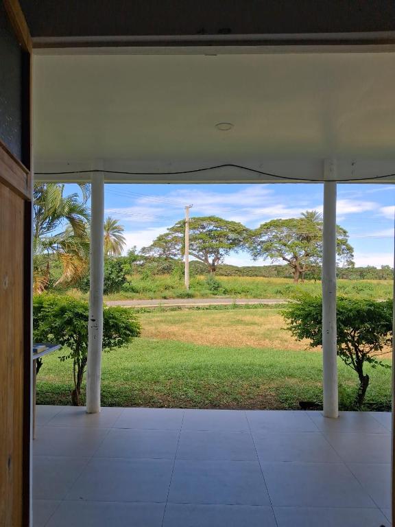 an open room with a view of a field with trees at DELAILOA ADVENTURES Homestay with Tom in Nadi