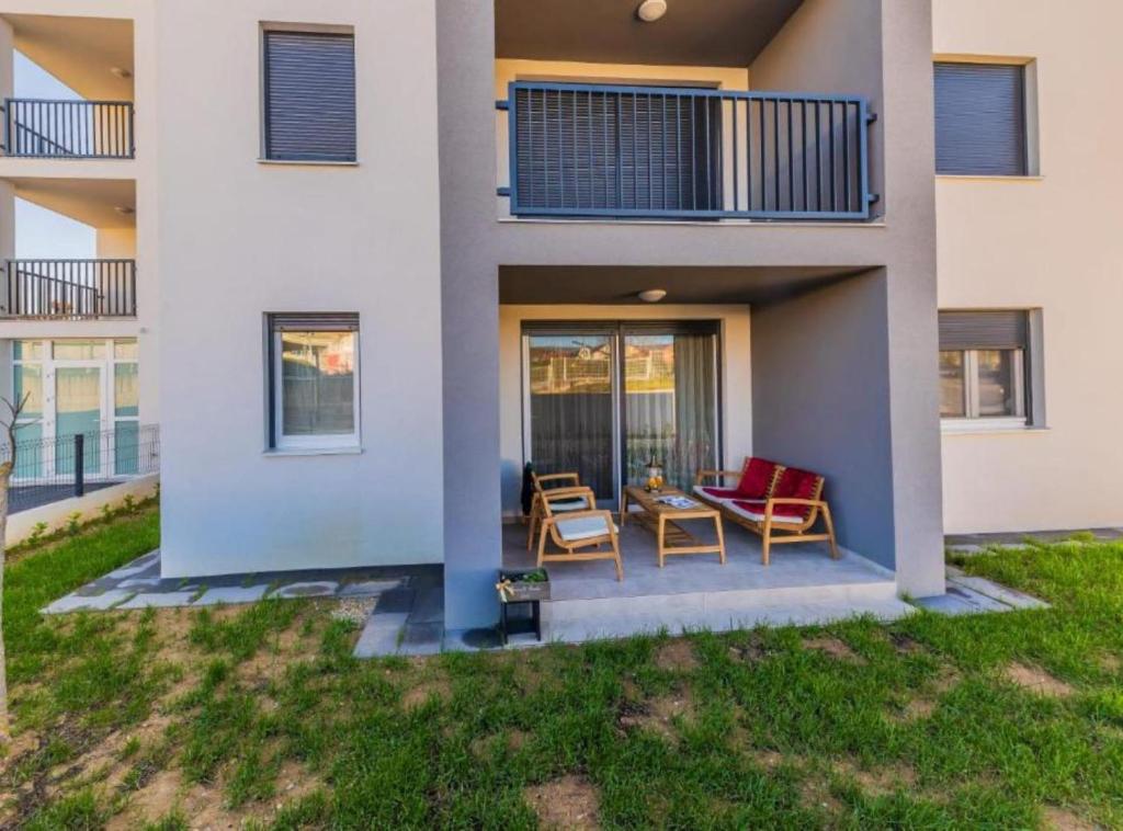 a house with two chairs and a table on a patio at Deluxe Apartment Bono in Sinj