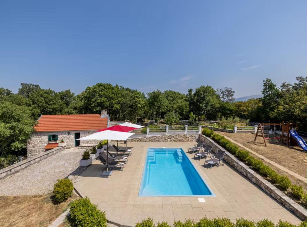 an outdoor swimming pool with chairs and a playground at Villa Pax in Studenci