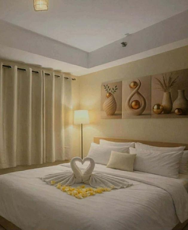 a bedroom with a white bed with a heart on it at Shore Residences 1 tower D in Manila