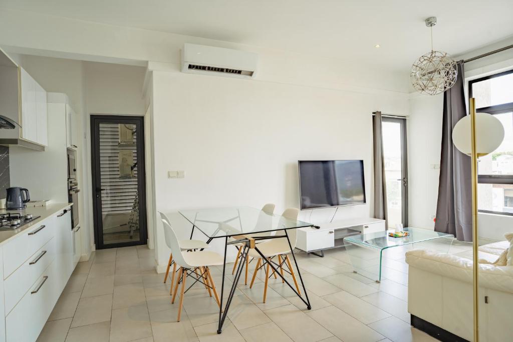 a kitchen and dining room with a glass table and chairs at Ebene City Centre - 2 Bedroom Apartment in Ebene