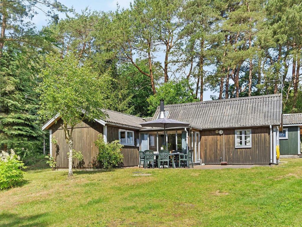 a cabin with a table and chairs in a yard at 7 person holiday home in Kolind in Kolind