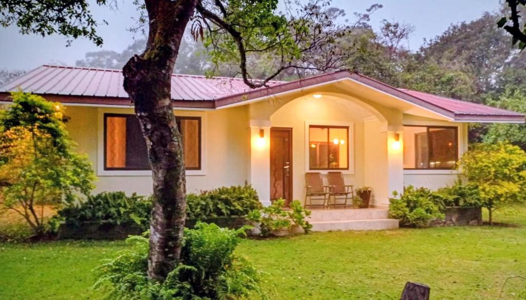 a house with a green lawn in front of it at Casa Mirango Boquete in Boquete