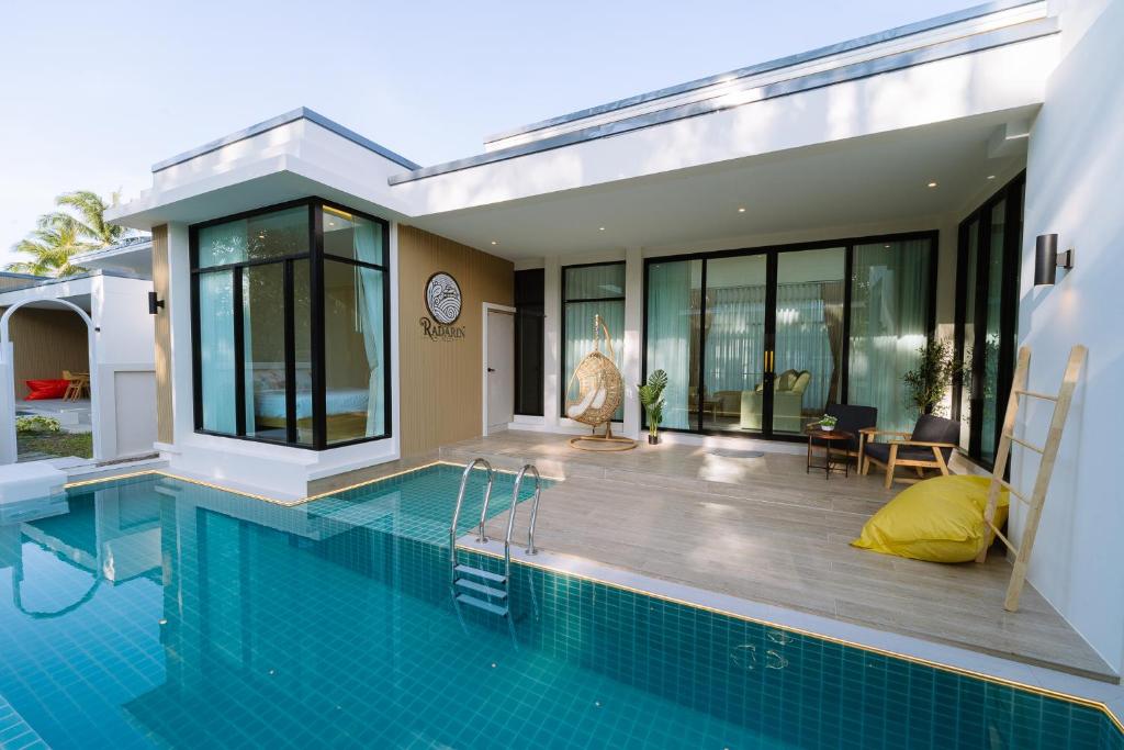 a house with a swimming pool next to a house at Radarin Villa in Ban Khao Kloi