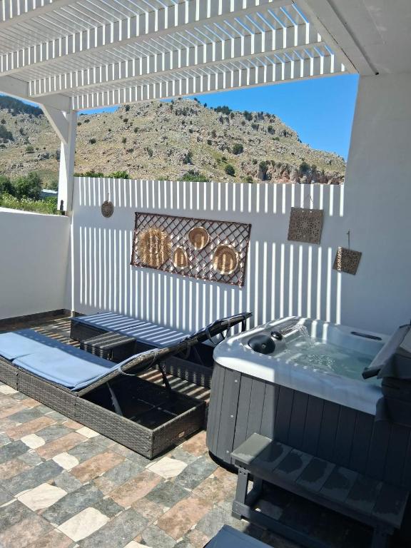 a patio with a hot tub and a grill at Stergios Suite with Private Jacuzzi in Kolymbia