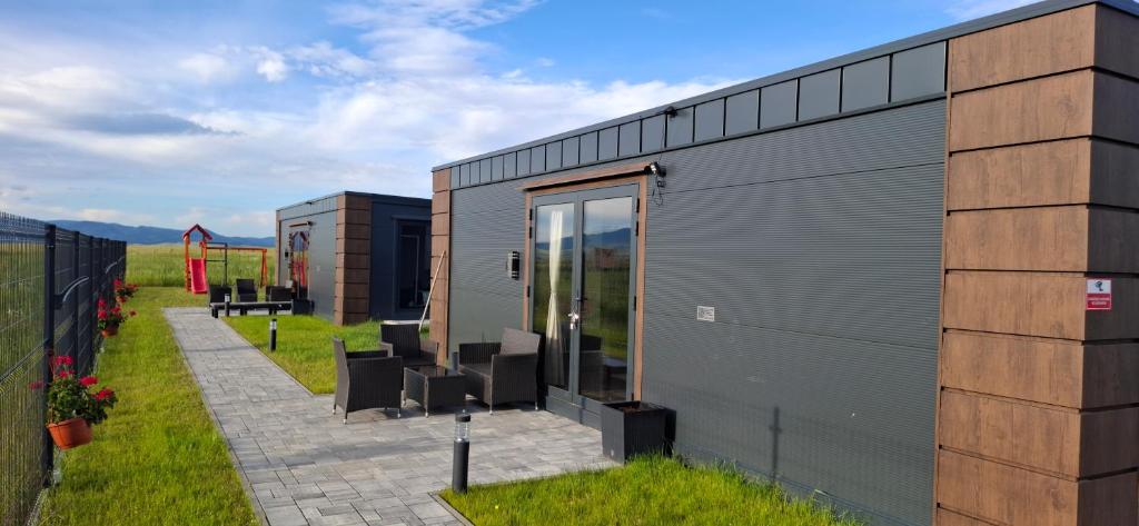 a metal building with a patio and grass at DuoDomkyTa3 in Spišská Belá