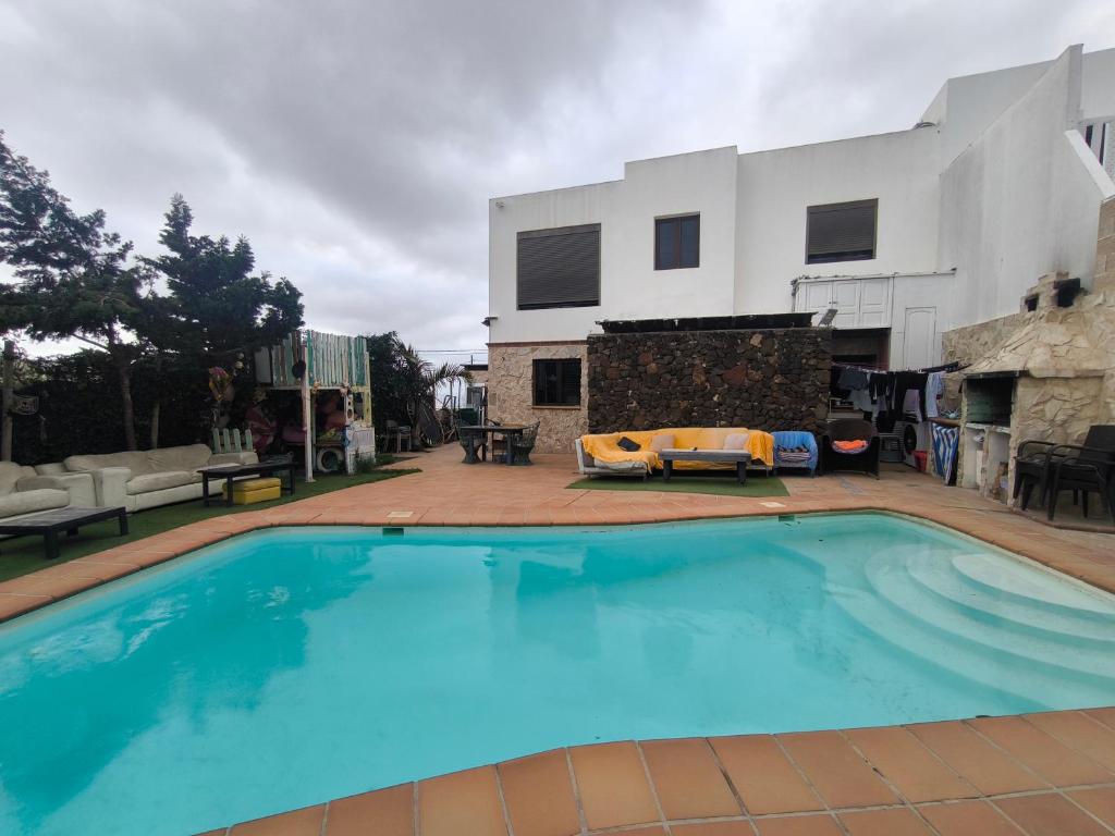 a large blue swimming pool in front of a building at LANZATE! in Tinajo