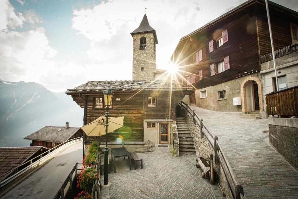 um edifício com uma igreja com uma torre de relógio em Pfründhaus em Guttet-Feschel