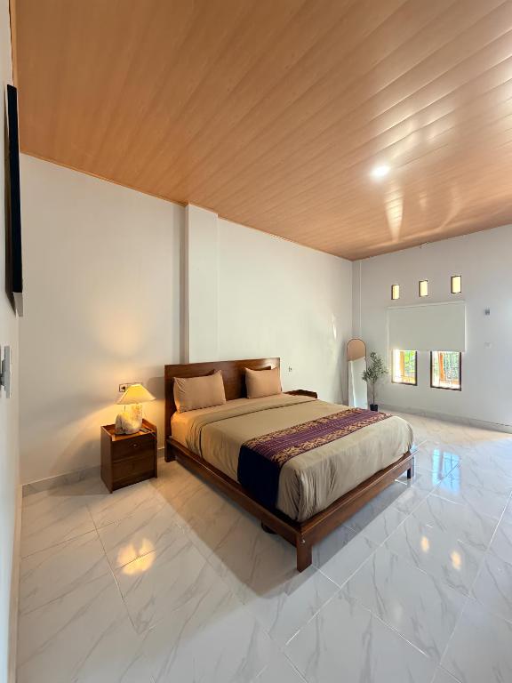 a large bedroom with a bed and a night stand at Manta Manta Guesthouse in Labuan Bajo