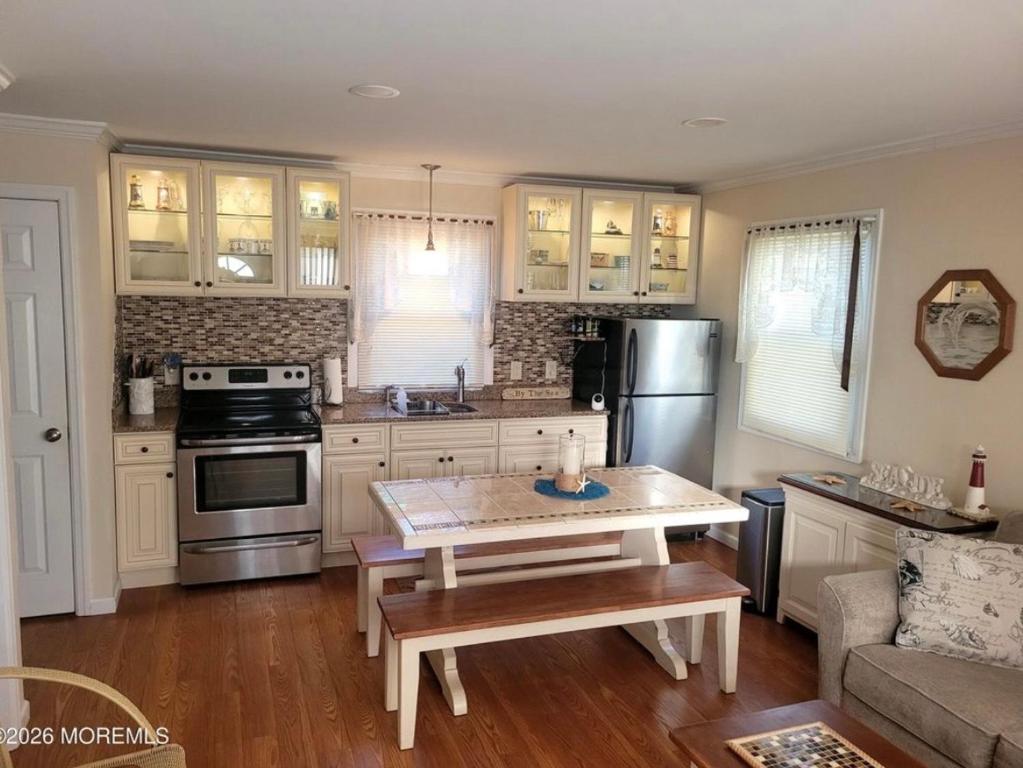 a kitchen with a table and a stove and refrigerator at Cozy Condo in Seaside Heights