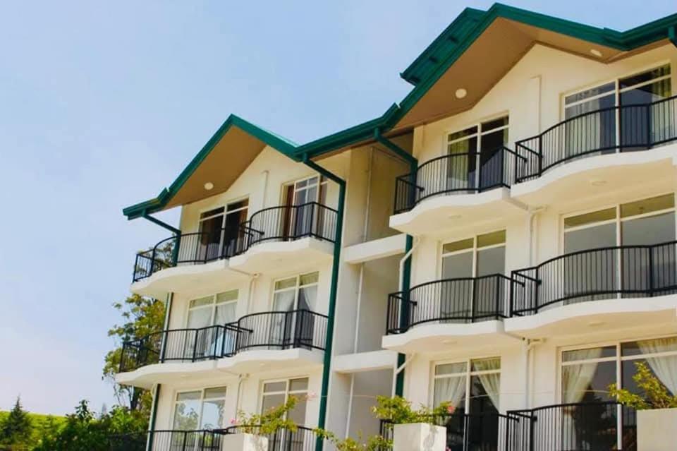 a large white building with balconies on it at Lake Infinity Luxury Condos in Nuwara Eliya