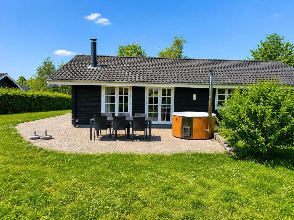 a house with a table and chairs in front of it at Lovely Cottage With Secluded Garden in Rødby