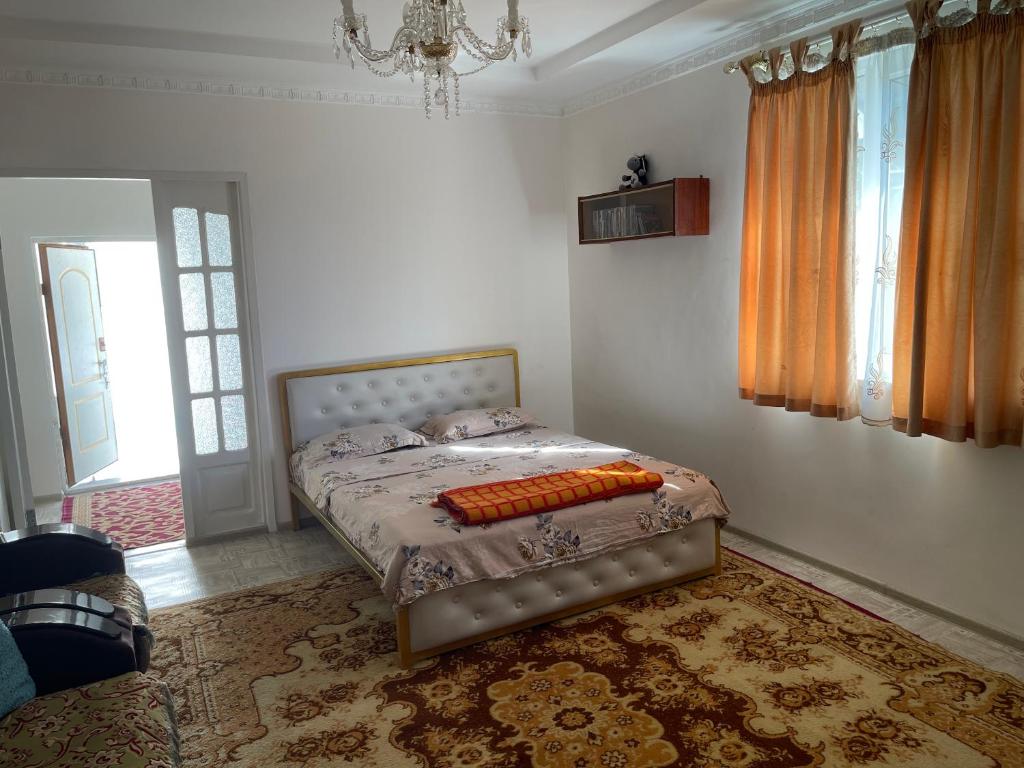 a bedroom with a bed and a chandelier at Жилье на природе с бассейном in Tashkent